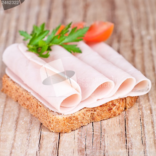 Image of bread with sliced ham, fresh tomatoes and parsley