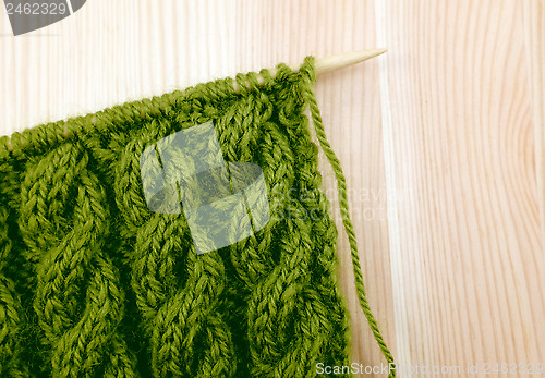 Image of Green cable knitting stitch on the needle