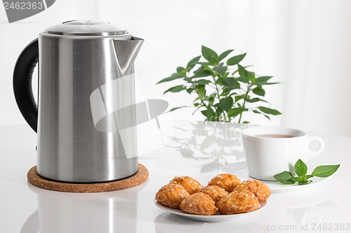 Image of Electric kettle, teacup and cookies