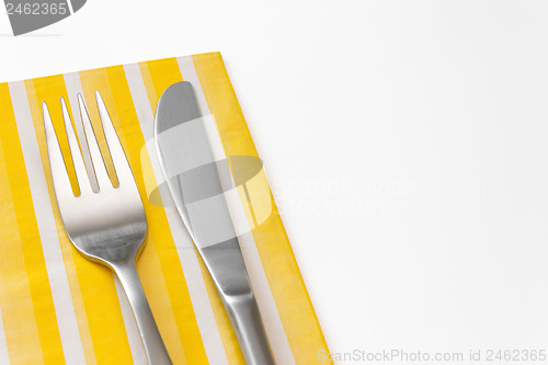 Image of Fork and knife on a yellow napkin