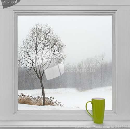 Image of Winter landscape seen through the window and green cup