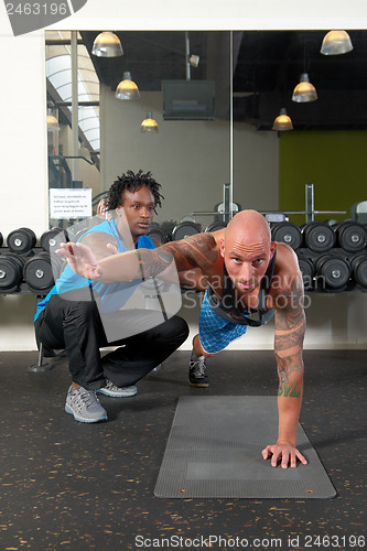 Image of Man with trainer in gym