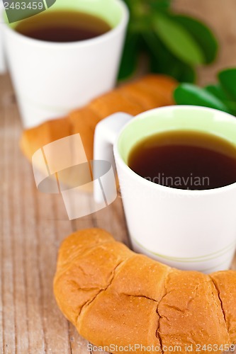 Image of two cups of tea and fresh croissants 