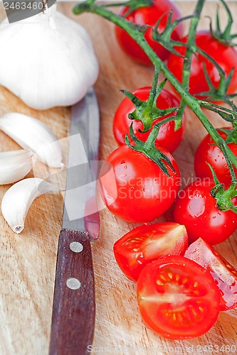 Image of fresh tomatoes, garlic and old knife