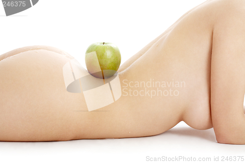 Image of naked woman torso with green apple