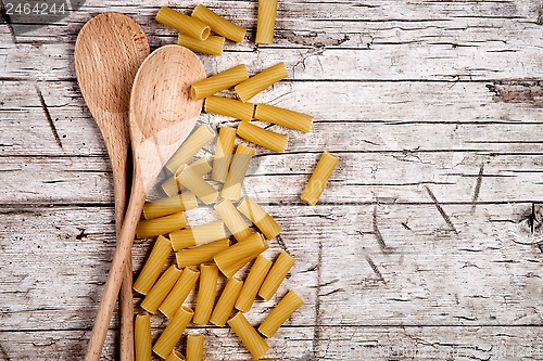 Image of raw macaroni and wooden spoons 