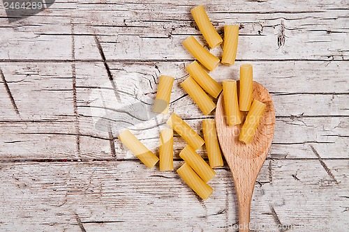 Image of raw macaroni and wooden spoon 