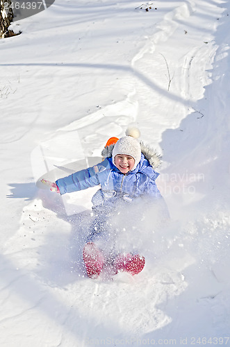 Image of Little girl on a sled in the winter