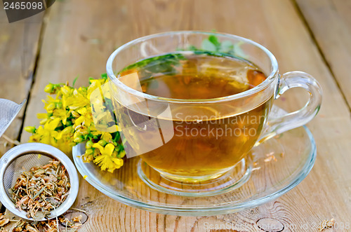 Image of Herbal tea from tutsan in strainer with cup