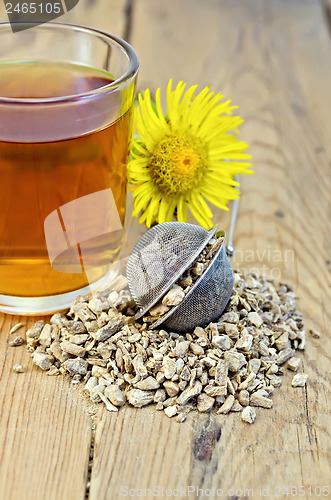 Image of Herbal tea from the root of elecampane in a strainer with a mug