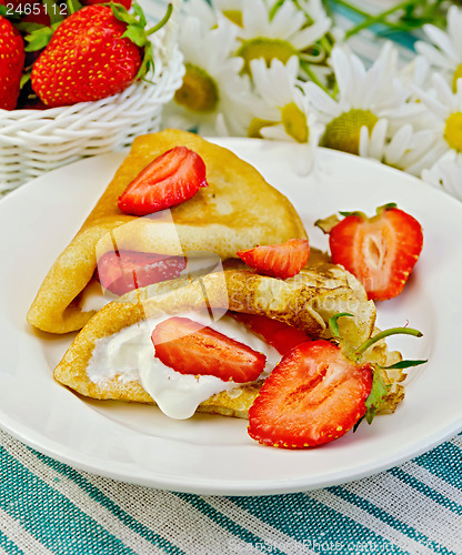 Image of Pancakes with strawberries and daisies on a napkin