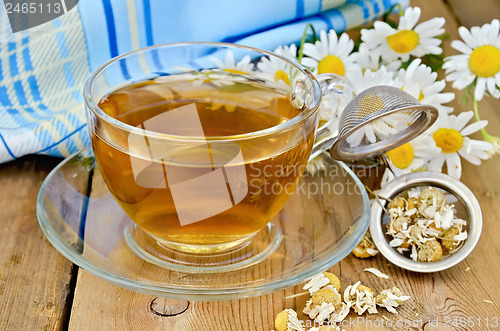 Image of Herbal chamomile tea with a strainer and a glass cup
