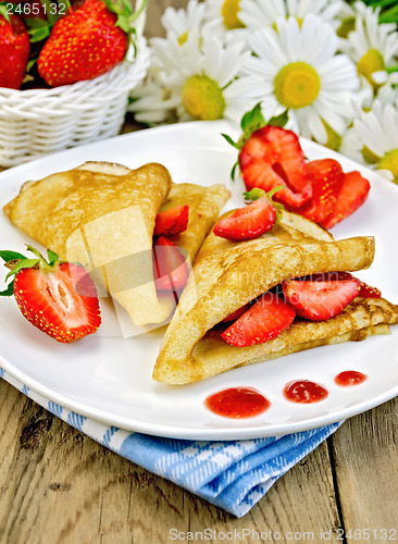 Image of Pancakes with strawberries and jam on the board