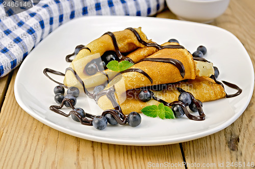 Image of Pancakes with blueberries and chocolate syrup