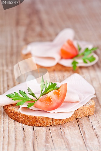 Image of bread with sliced ham, fresh tomatoes and parsley