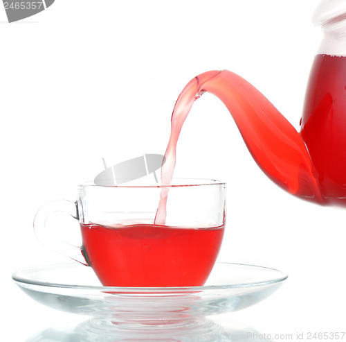 Image of Tea being poured into glass tea cup isolated