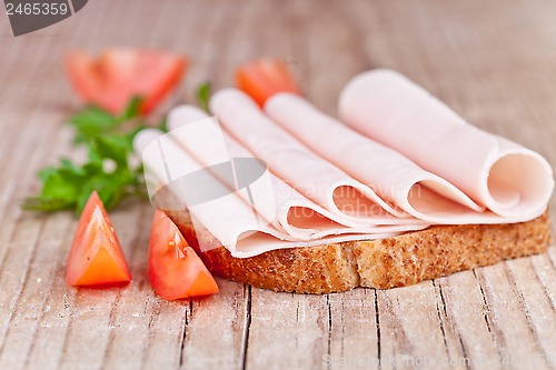 Image of bread with sliced ham, fresh tomatoes and parsley