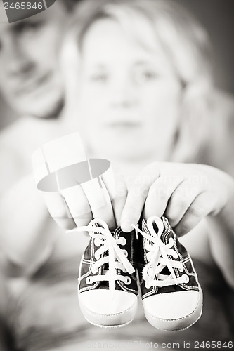 Image of pregnant woman and husband with a child's shoe