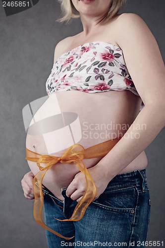 Image of pregnant woman with ribbon around her tummy