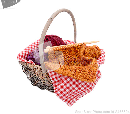 Image of Purple, red and orange wool with knitting in a basket