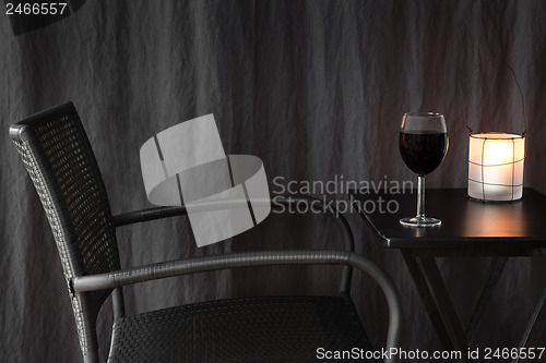 Image of Lantern decorating a table with glass of wine