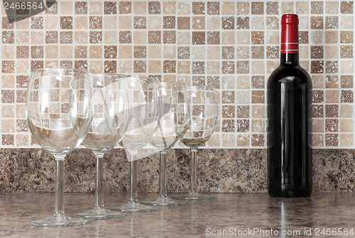 Image of Bottle of wine and glasses on kitchen countertop