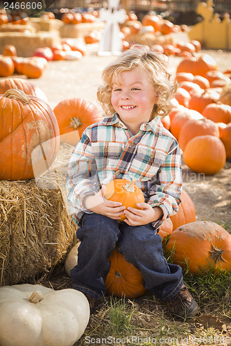 Image of Little Boy Sitting and Holding His Pumpkin at Pumpkin Patch
