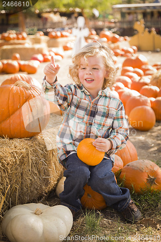 Image of Little Boy Sitting and Holding His Pumpkin at Pumpkin Patch
