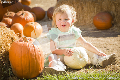 Image of Adorable Baby Girl Holding a Pumpkin at the Pumpkin Patch
