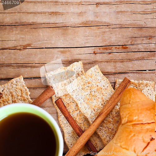 Image of cup of coffee, crackers and fresh croissant for breakfast