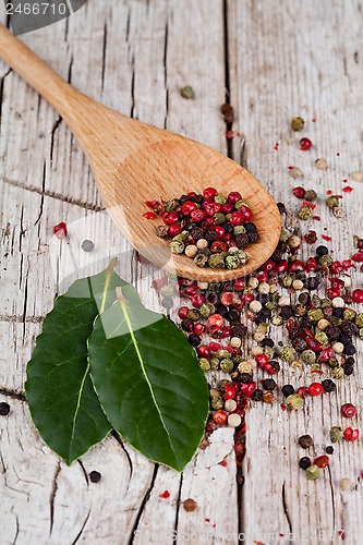 Image of mixture of peppers in spoon and bay leaves 