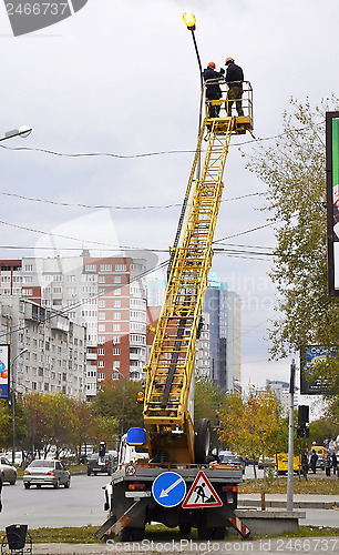 Image of Electricians repair a streetlight.