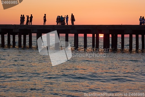 Image of People on the old sea pier at sunset