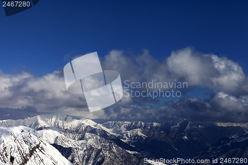 Image of Winter sunlit mountains and sky with clouds