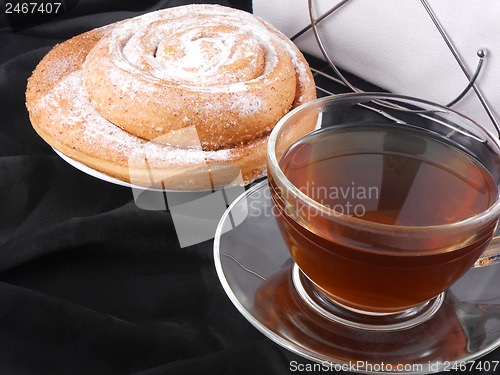 Image of Hot tea with sweet cake on black background
