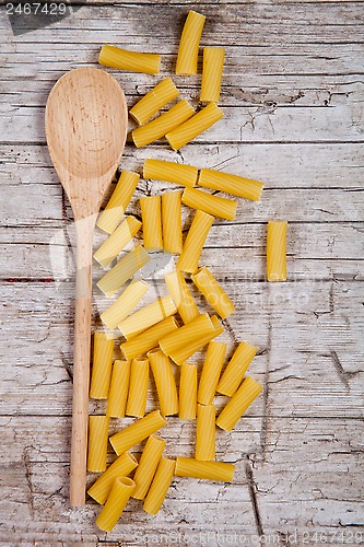 Image of raw macaroni and wooden spoon 