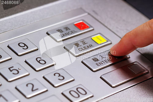 Image of Hand entering personal identification number on ATM dial panel