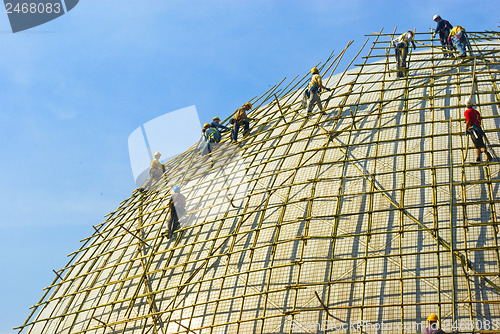 Image of Closeup of construction worker assembling scaffold on building s