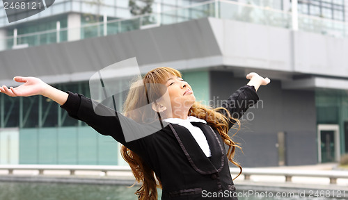 Image of Woman relaxing with arms open enjoying her freedom and office bu