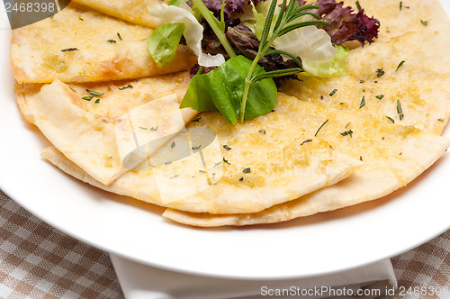 Image of garlic pita bread pizza with salad on top