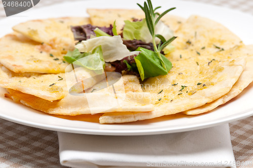 Image of garlic pita bread pizza with salad on top