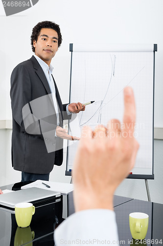Image of Businessman Explaining Graph With Colleague Raising Hand
