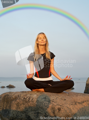 Image of meditation at the seashore under rainbow