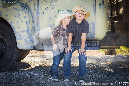 Image of Two Young Boys Wearing Cowboy Hats Leaning Against Antique Truck