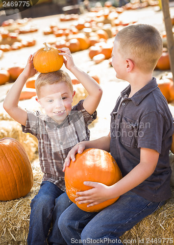 Image of Two Boys at the Pumpkin Patch Talking and Having Fun
