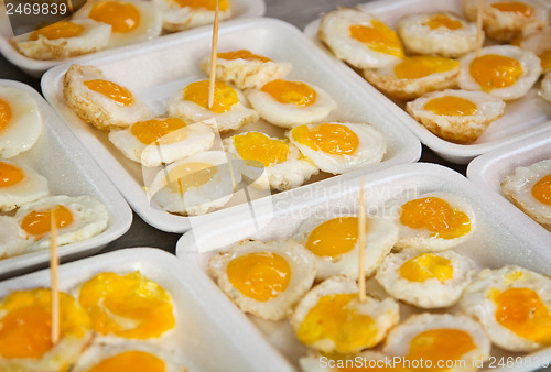Image of Fried quail eggs on the market close up
