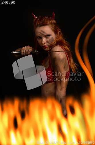 Image of dark red devil girl with a knife in fire