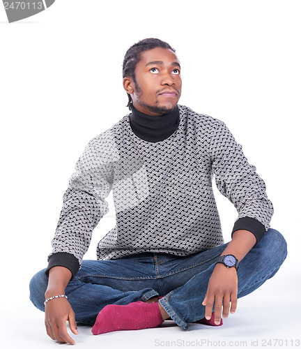 Image of Young African-American male sitting on the ground