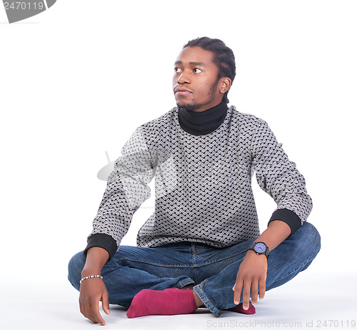 Image of Young African-American male sitting on the ground