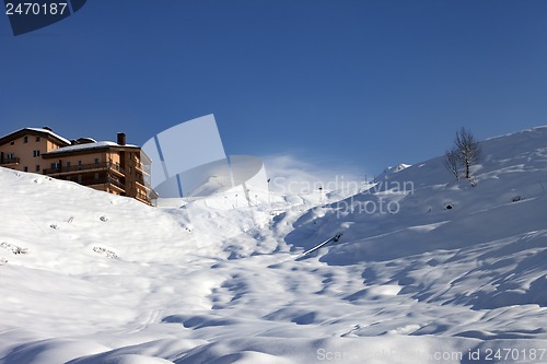 Image of Off-piste slope and hotel in winter mountains